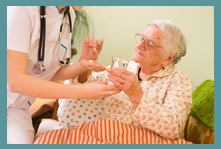 nurse giving medicine to senior woman